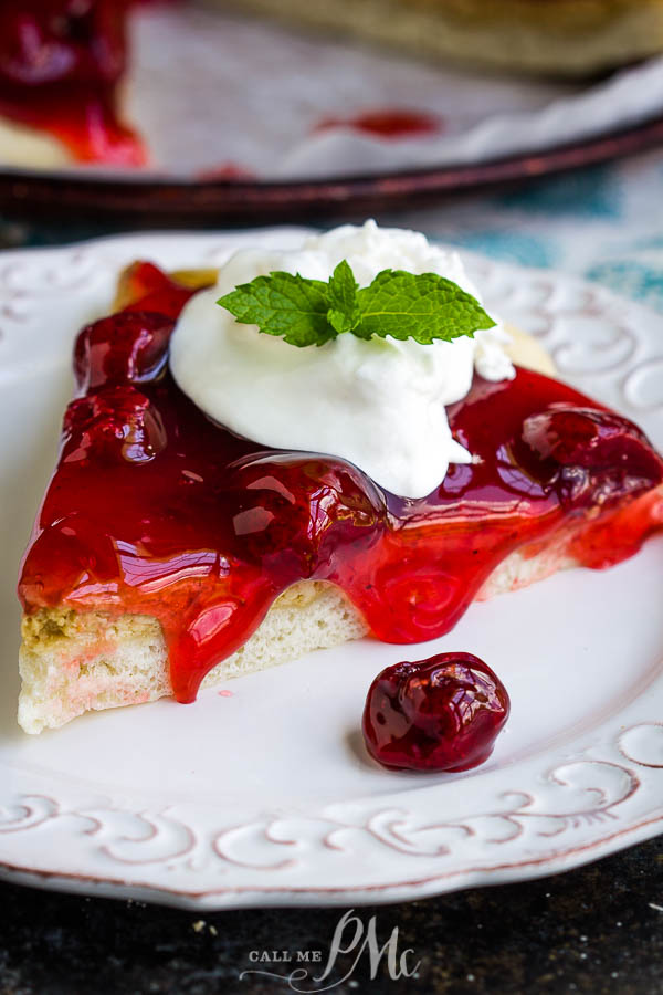 An easy recipe for a delicious dessert, Strawberry Cheesecake Pizza Recipe has a really yummy pizza crust topped with sweetened cream cheese and strawberry pie filling. #pizza #dessert #recipe #dessertpizza #strawberry #callmepmc Slice of dessert with whipped cream.