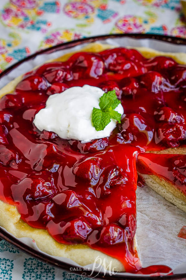An easy recipe for a delicious dessert, Strawberry Cheesecake Pizza Recipe has a really yummy pizza crust topped with sweetened cream cheese and strawberry pie filling. #pizza #dessert #recipe #dessertpizza #strawberry #callmepmc Dessert on a plate.