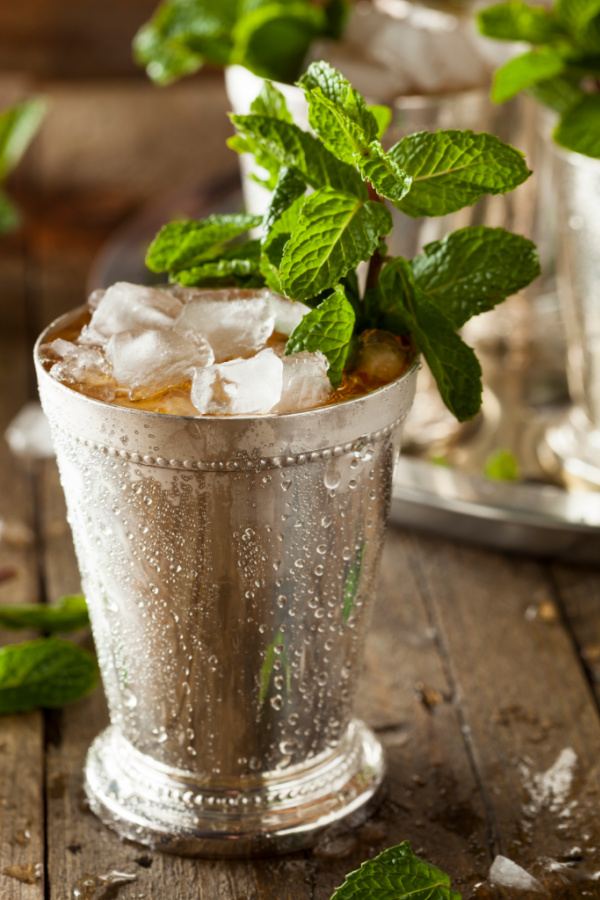 A classic ingredient mint julep cocktail made with bourbon, crushed mint, ice, and water and served in a silver julep cup. #mintjulep #KentuckyDerby #ChurchhillDowns #horserace #cocktail #bourbon #bourboncocktails #recipes #cocktailrecipes #callmepmc
