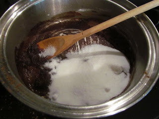 Stirring sugar into cocoa powder and butter mixture for chocolate gravy recipe.