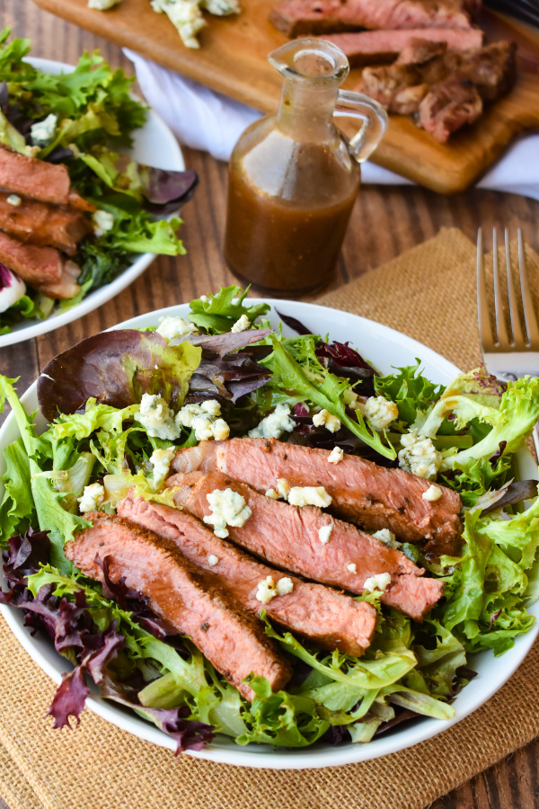 Black and Blue Salad is a hearty entree salad recipe with a spice-rubbed, blackened steak, blue cheese crumbles, and balsamic salad dressing. #salad #steak #steaksalad #blackenedsteak #bluecheese #recipe #entree #dinner #dinnersalad #entreesalad Black and Blue Salad