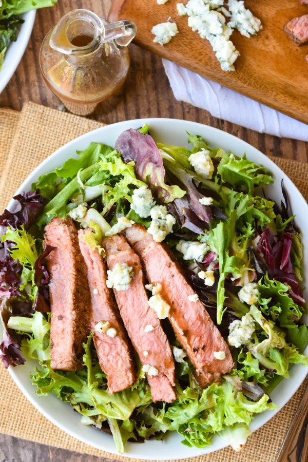 Black and Blue Salad is a hearty entree salad recipe with a spice-rubbed, blackened steak, blue cheese crumbles, and balsamic salad dressing. #salad #steak #steaksalad #blackenedsteak #bluecheese #recipe #entree #dinner #dinnersalad #entreesalad