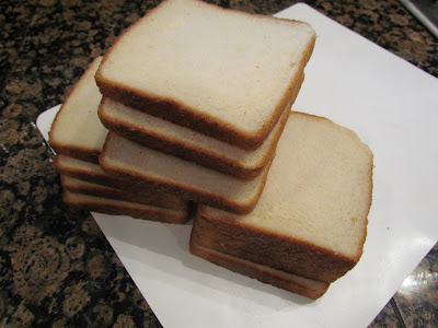 slices of white bread stacked on a white plate.