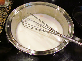 adding milk to roux for béchamel sauce.