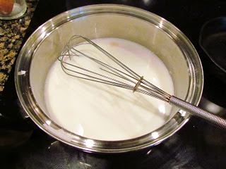 adding milk to roux for bรฉchamel sauce.