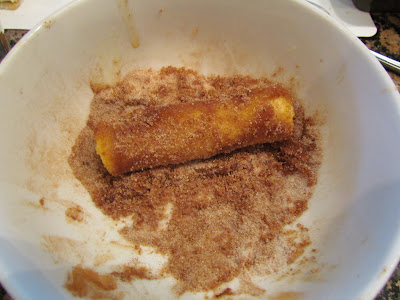 rolling cream cheese dessert in cinnamon sugar.