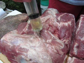 injecting a Boston butt with seasonings.