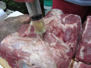 injecting a Boston butt with seasonings.