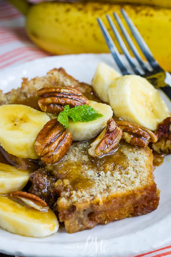 My version of Bananas Foster, Peanut Butter Bread Bananas Foster Bananas, is a decadent rum-lace caramel sauce over peanut butter bread. #dessert #recipe #bananas #bananasfoster #caramel #rum #easy Close-up of banana bread topped with banana slices, pecans, caramel sauce, and a mint leaf on a white plate with a fork, evoking the rich flavors of Bananas Foster.