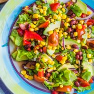 Traditional Vegetarian American Southwest Salad with vegetables, avocado, beans and corn on a rustic background