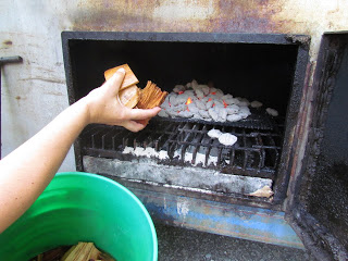 adding wood chips to a smoker fire box.