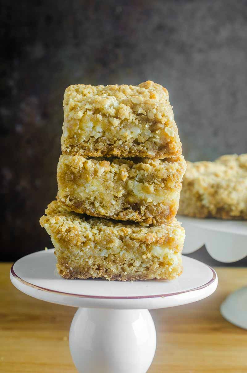 An oatmeal cookie and cheesecake collide in this Oatmeal Cookie and Cream Cheese Bars recipe. They are luscious, sweet, and can be made quickly and easily. #dessert #recipe #creamcheese #oats Oatmeal Cookie and Cream Cheese Bars