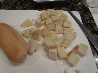 cutting cubes of bread for pecan pie bread pudding recipe.