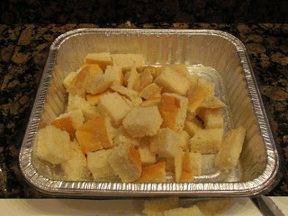 bread cubes in pan. A tray of croutons on a counter.