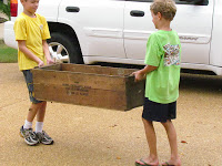 Little boys carrying a homemade shoe rack.