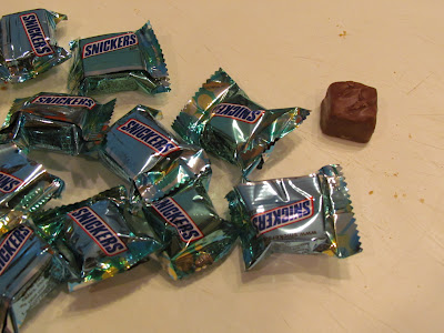 A pile of snickers candy wrappers on a table.