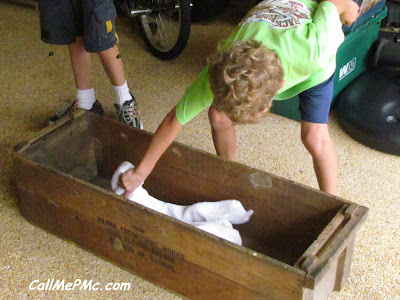 Child cleaning dust and debris off of a wood shoe rack.