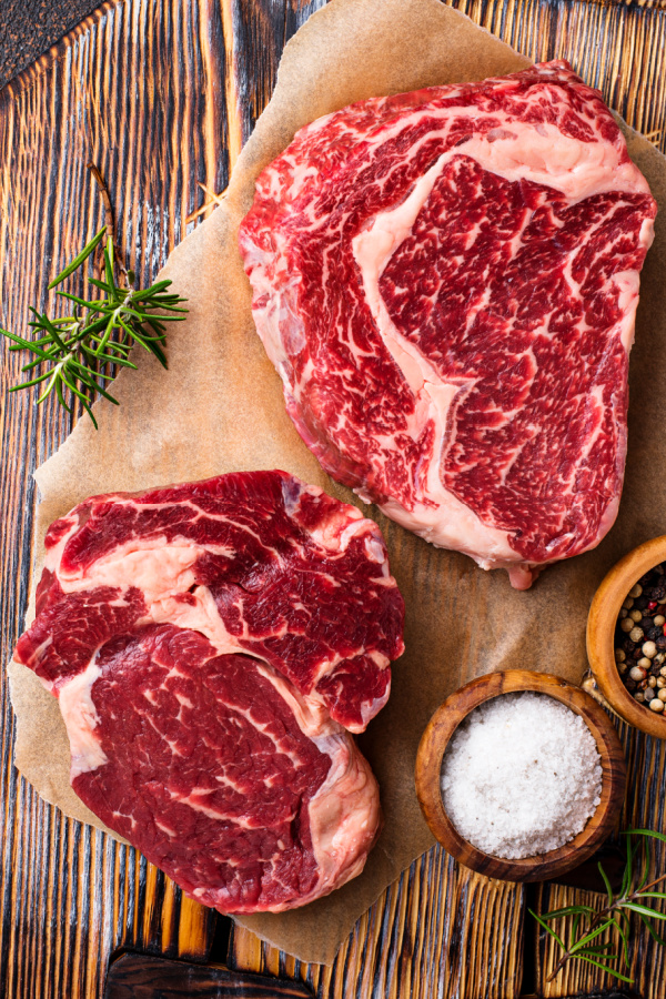 Raw Ribeye on cutting board with seasonings