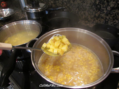 diced potatoes on a slotted spoon above a soup pot.