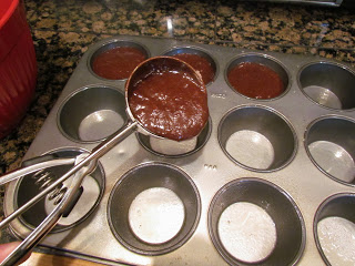 spooning brownie batter into a muffin pan for brownie bites.