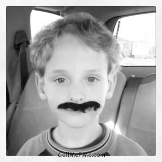 little boy with painted on mustache.