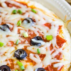 To Die For Pizza Dip is a cheesy, gooey dip that tastes like everyone's favorite comfort food. A layer of cream cheese is topped with tomato sauce and your favorite pizza toppings.