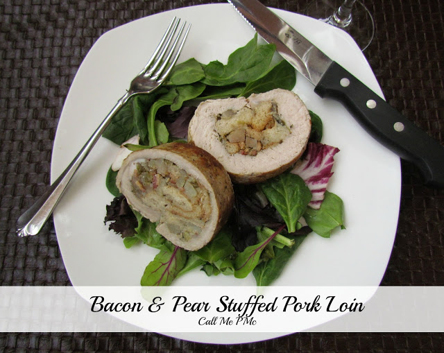 A plate featuring a succulent bacon and pear stuffed pork loin rests on a bed of mixed greens, perfectly accompanied by a knife and fork.