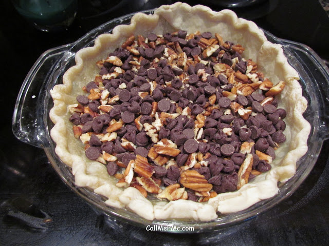 Chocolate chips and chopped pecans in an unbaked pie crust.