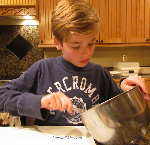 young boy stirring ingredients in mixing bowl.