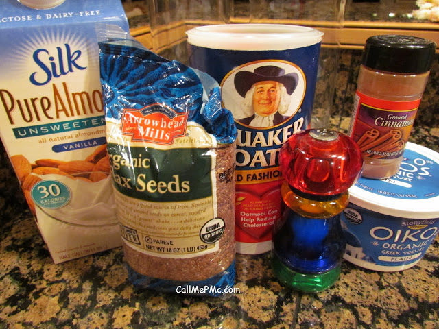 containers of rolled oats, unsweetened almond milk, flax seed, Greek yogurt, and honey on a kitchen counter.