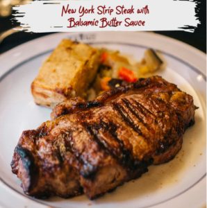 new york strip steak on a white plate.