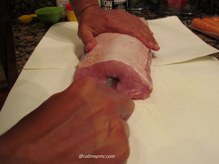 Cutting into a large piece of raw meat.