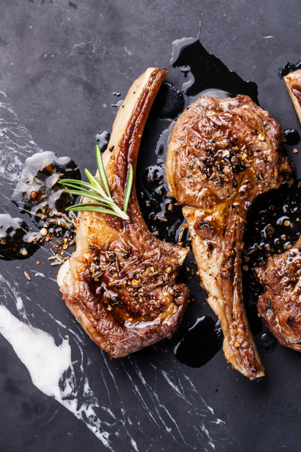 Roasted lamb ribs with spices on black marble background Grilled Lamb Lollipops are so easy to make and taste wonderful.ย They the perfect recipe for entertaining and the holidays!