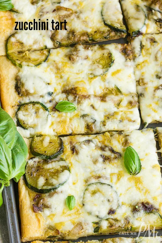 Fresh Zucchini Tart starts with an easy premade crust, topped with zucchini then smothered with cheese. #zucchini #baked A pizza, baked to perfection and cut into rectangular pieces, is topped with melted cheese and garnished with aromatic basil leaves.