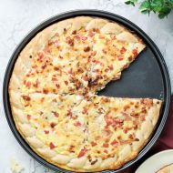 This Cheddar Ham Breakfast Pizza recipe has eggs, cheese, and ham baked into a thick, chewy, store-bought crust! It checks all the boxes for speed, budget, and flavor.