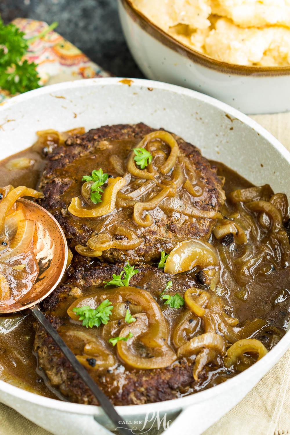 steak and gravy Hamburger steak with onions and brown gravy in a sauce pan.