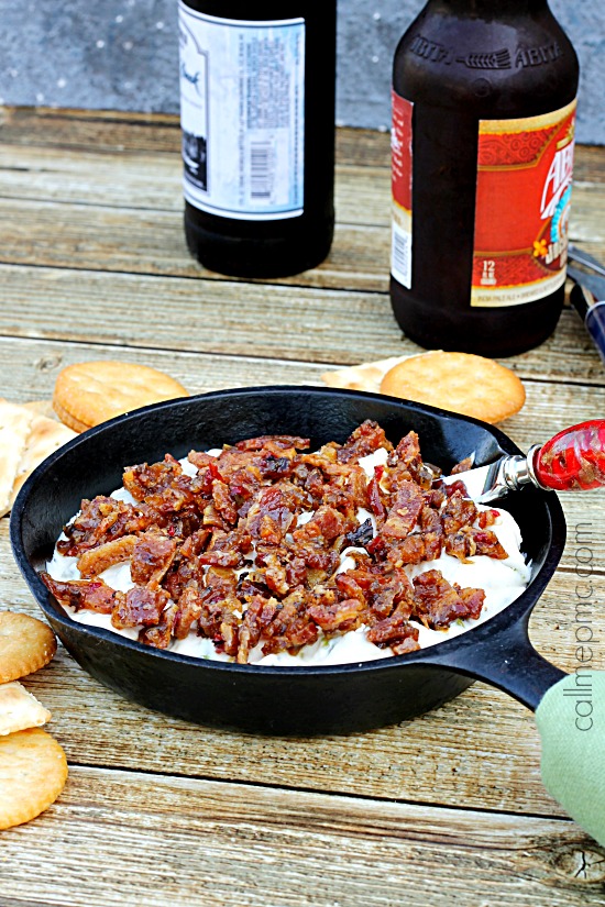 Salty, creamy and cheesy this Creamy Corn Bacon Dip is perfect for potluck, parties or tailgating. One bite of this flavorful sweet corn and crispy bacon and all your friends and family will be hooked! skillet of creamy corn dip with bacon
