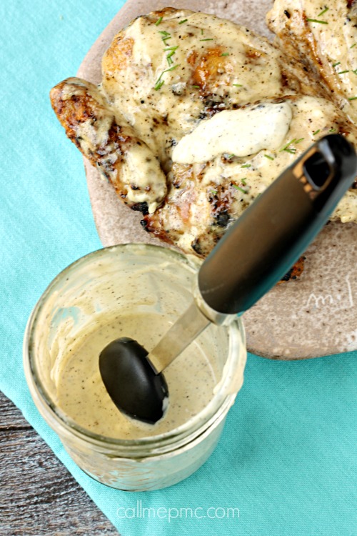 White Barbecue Sauce - It's creamy. It's tangy. It's versatile. It's the perfect dip or spread. Pair this White BBQ Sauce with fried or grilled chicken, pork, fries, sandwiches, or as a base for chicken salad. A spoon dives into a jar of creamy pepper sauce, reminiscent of a tangy sauce, held just above the jar.