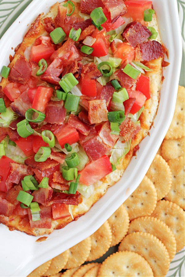 dish with bacon lettuce and tomato BLT Dip is quick, easy, tasty, & the perfect appetizer. This creamy dip, served hot or cold, is filled with bacon, tomatoes, & green onions.