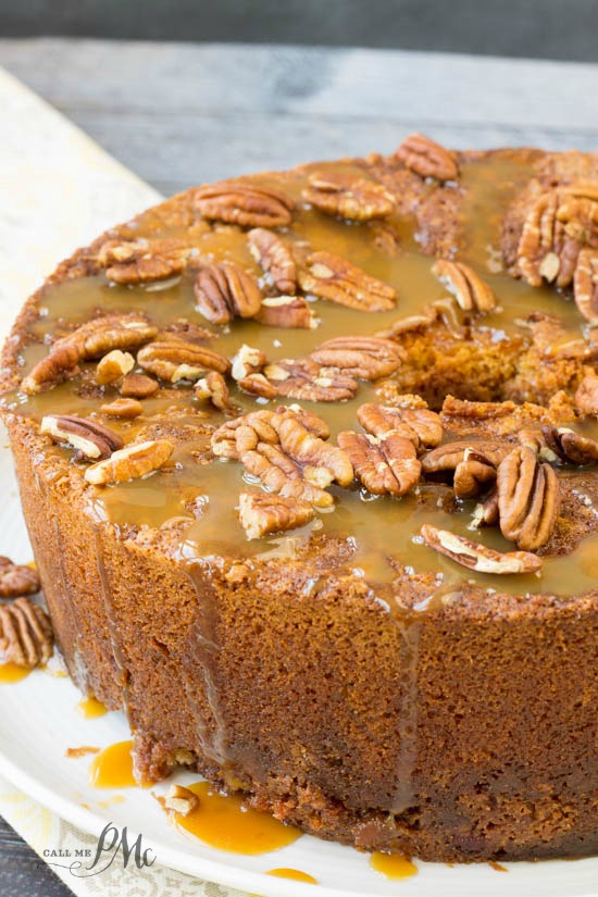 Homemade Pecan Pie Pound Cake Recipe is a soft, buttery pound cake recipe that's studded with sugared pecans and caramel. Whole cake on a plate with nuts and sauce.