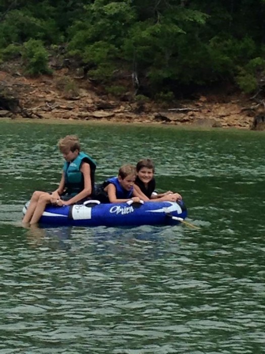 3 kids on an inner tube on Smith Lake in Mississippi.