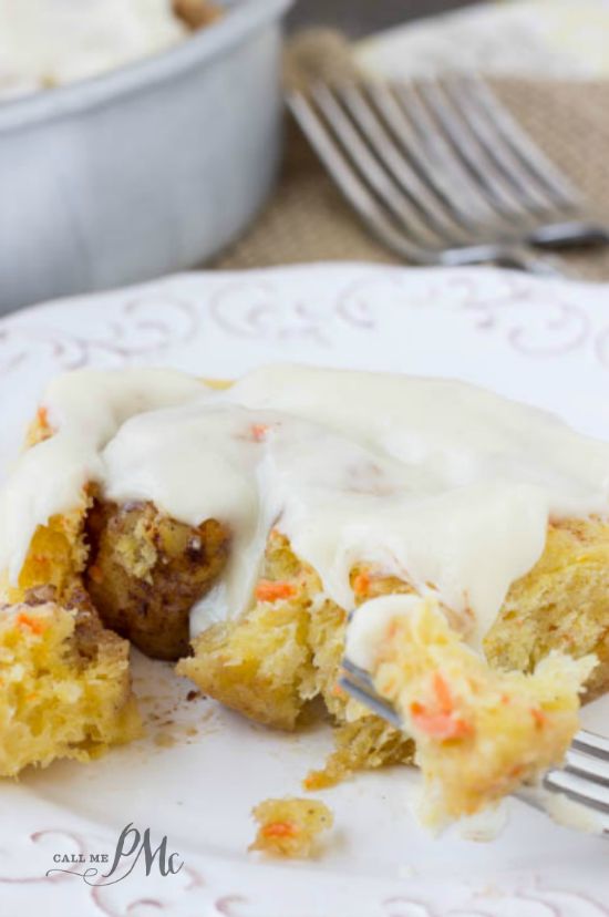 Scratch Made Carrot Cake Cinnamon Rolls with Cream Cheese Frosting recipe warm sweet rolls filled with cinnamon and butter and topped with cream cheese frosting oozing down into the warm cinnamon rolls! Great breakfast and brunch recipe. Sweet rolls with fork.