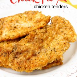 Two breaded and fried chicken tenders sit on a white decorative plate, with text above reading "Copycat Chick-fil-A Chicken Strips" for the perfect homemade version of your favorite restaurant treat.