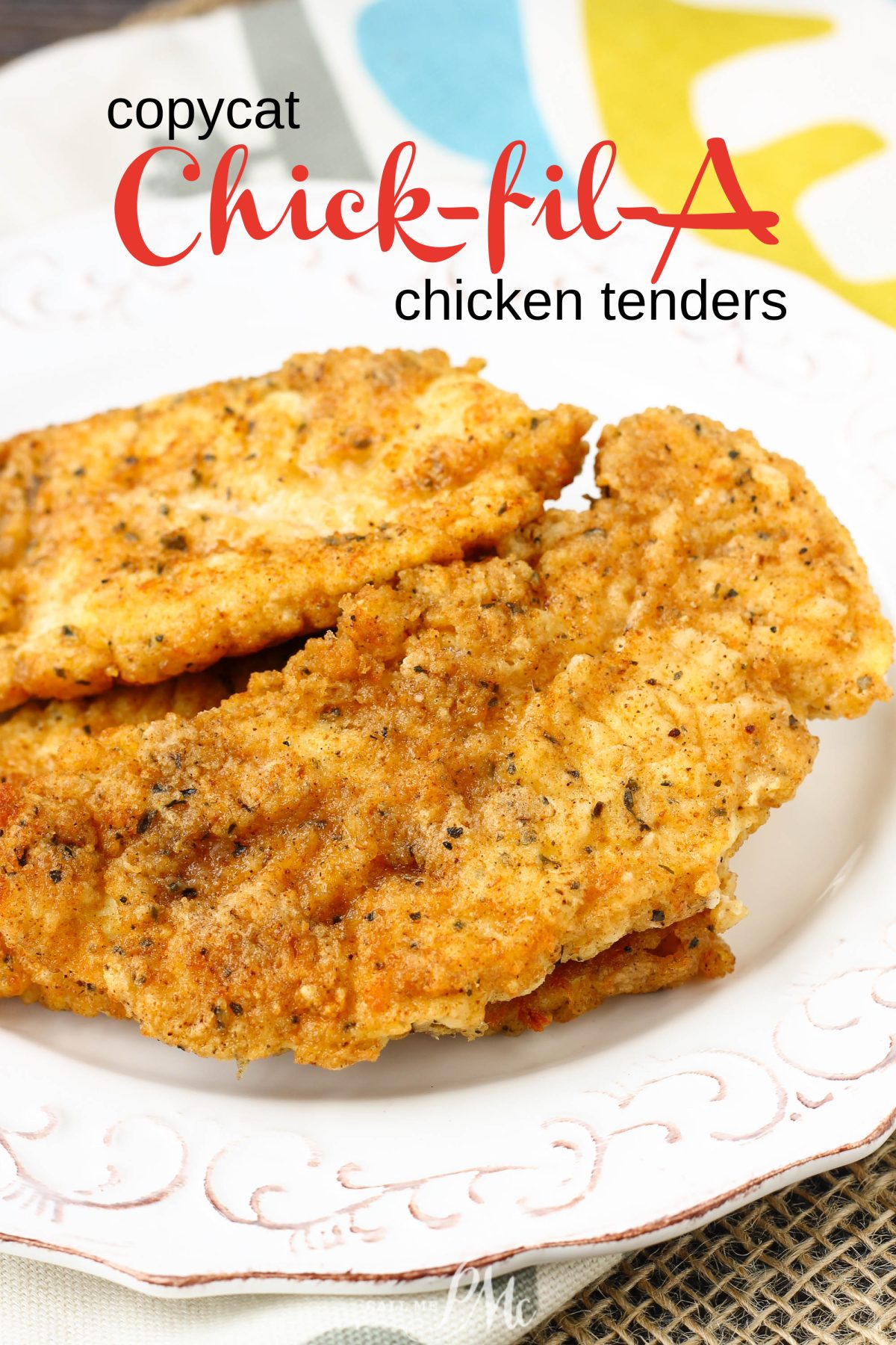 Two breaded and fried chicken tenders sit on a white decorative plate, with text above reading "Copycat Chick-fil-A Chicken Strips" for the perfect homemade version of your favorite restaurant treat.