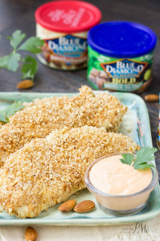 containers of Blue Diamond almonds behind a plate of baked chicken tenders.