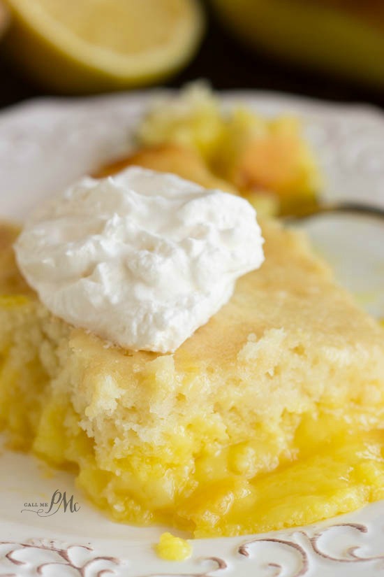 dollop of whipped cream on top a slice of lemon lava cake.