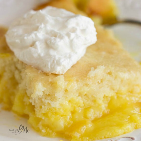 slice of lemon lava cake, close up, topped with whipped cream.