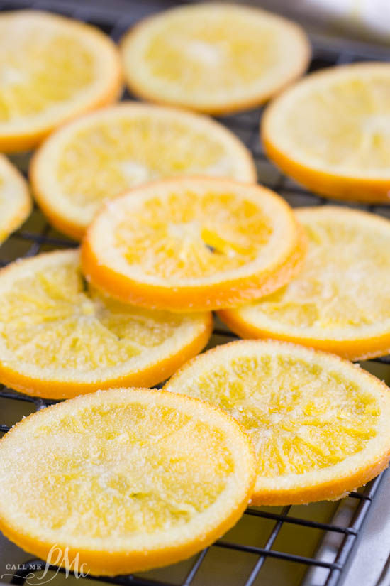 Close-up of candied orange slices arranged in a single layer on a cooling rack.