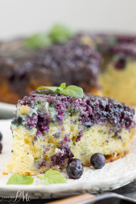 Homemade Blueberry Upside-down Cake is unbelievably good. Blueberries and a caramel glaze ooze down into the tender yellow cake making it moist and decadent. This cake recipe has quickly become one of my all-time favorites! Homemade Blueberry Upside-down Cake slice on a plate.