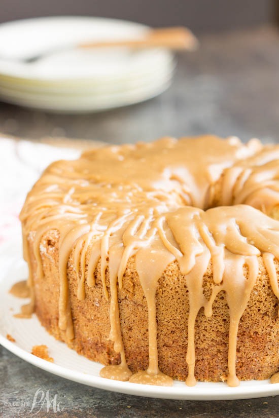 Whole whipping cream pound cake with caramel icing on a table.